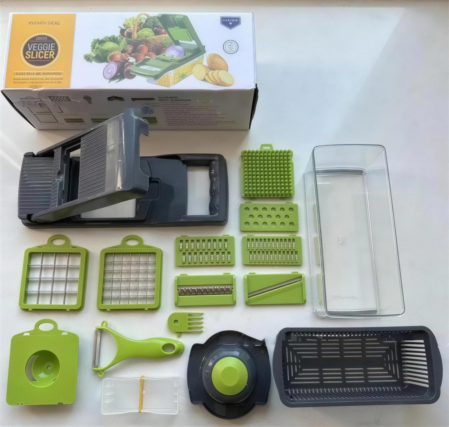 Vegetable chopper kit laid out on kitchen counter — blades, peeler, catch container